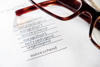 Gibt es einen NC für Hotelmanagement? Brille, die auf Zeugnisausschnitt liegt