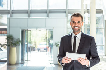 Businessmann sieht lachend in die Kamera