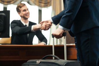Hotelmanager schüttelt Hotelgast die Hand