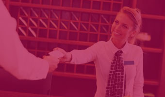 Rezeptionistin übergibt Hotelgast seine Zimmerkarte