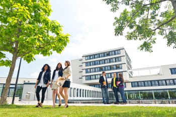 Studenten gehen auf Campusgelände in Gruppen