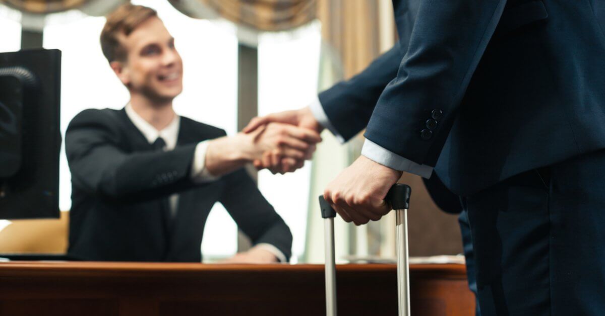 Junger Front Office Manager schüttelt Gast die Hand