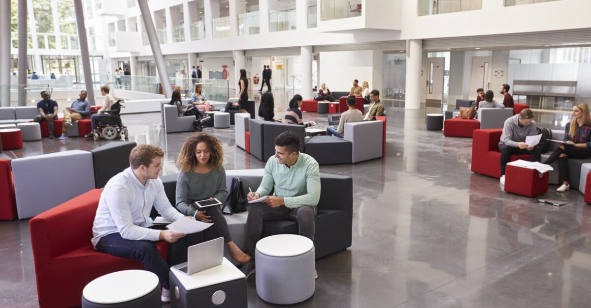 Viele Studenten sitzen in Foyer einer Hochschule